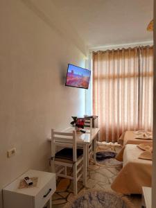 a room with a desk and a tv on the wall at Mert Jacellari Guesthouse in Pogradec