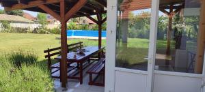 a patio with a table and a glass door at Mirella apartman in Palić