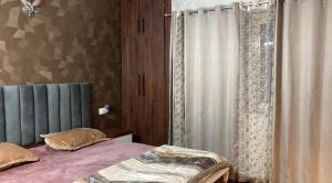 a bedroom with a bed and a window with curtains at 22nd Weekend Stays in Bhīm Tāl