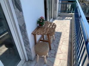 a small wooden table and stool on a balcony at Mok's House in Kavála +22 photos