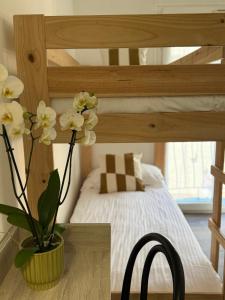 a vase of flowers on a table in a bedroom at Hotel Provencal in Saint-Raphaël