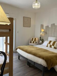 a bedroom with a large bed and a chair at Hotel Provencal in Saint-Raphaël