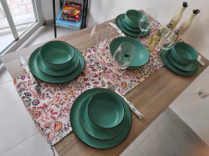 a table with green plates and wine glasses on it at Mok's House in Kavála