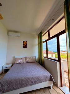 a bedroom with a bed and a large window at Mert Jacellari Guesthouse in Pogradec