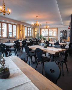 a restaurant with wooden tables and chairs and windows at Hotel Askania 1927 in Bad Wiessee
