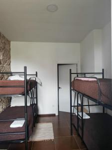 ein Zimmer mit drei Etagenbetten und einer Tür in der Unterkunft Albergue e AL O Brasão Valença in Valença