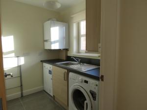 a kitchen with a washing machine and a sink at Anchor Gardens Villa in Lindal in Furness