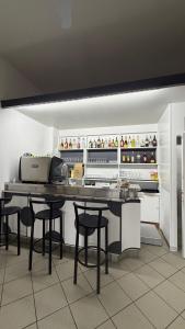 a kitchen with a counter with stools and a table at Hotel Primula in Lido di Savio