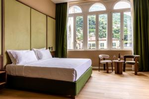 a bedroom with a bed and a large window at Hotel Vapore in Torno +150 photos