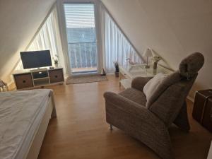 ein Wohnzimmer mit Sofa, Sessel und Fernseher in der Unterkunft FeWo Hofmann in Schwanewede