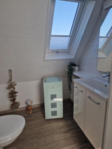 ein Badezimmer mit Toilette, Waschbecken und Fenster in der Unterkunft FeWo Hofmann in Schwanewede + 4 Fotos