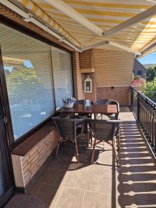 eine Terrasse mit Holztisch und Stühlen in der Unterkunft FeWo Hofmann in Schwanewede