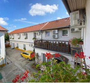 a yellow car parked in the courtyard of a house at Franc Llagami - Rooms in Vecsés