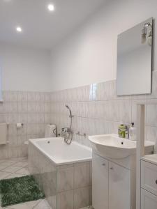 a white bathroom with a tub and a sink at Studio Szczawienko 2 in Wałbrzych