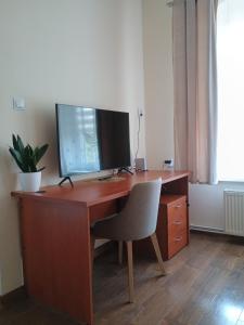 a wooden desk with a computer monitor and a chair at Studio Szczawienko 2 in Wałbrzych