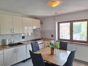 eine Küche mit Tisch und Stühlen und einem Fenster in der Unterkunft Villa Zorba in Bukarest