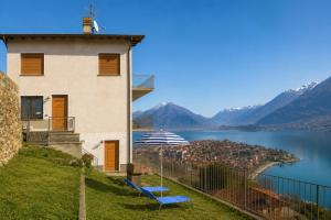 a building with two blue benches next to a body of water at Apartment Alex 1 in Domaso in Domaso