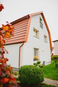 a white house with an orange roof at Guest house ''8 smilgos'' in Klaipėda