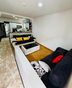 a living room with a white couch and yellow pillows at The Olive Tree Apartment in Ljubuški
