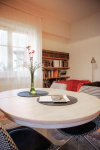 a dining room table with a vase of flowers on it at Guest house ''8 smilgos'' in Klaipėda