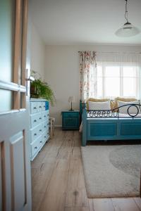 a bedroom with a blue bed and a window at Guest house ''8 smilgos'' in Klaipėda