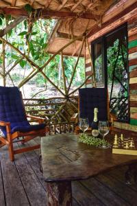 a room with a table and chairs and a chessboard and wine glasses at Nature Hill in Ko Mook