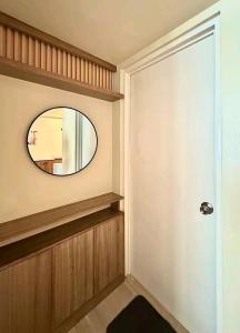 a hallway with a round mirror and a door at Ilo2stayAirbnb 1BR Luna in Iloilo City