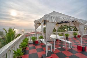 a gazebo on a balcony overlooking the beach at Hotel Salty Waves Baga in Baga