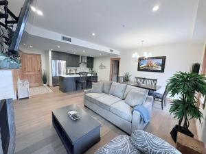 a living room with a couch and a table at Luxury Mountain Haven Views Hot Tub Central Bridgette Bar Main St in Canmore