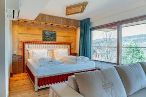 a bedroom with a bed and a couch and a window at Mountain Diamond Resort in Zakopane +267 photos