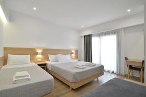 a hotel room with two beds and a desk at Anassa Suites in Leptokarya +156 photos