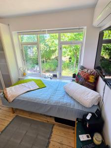 a bed in a room with a large window at Irenes Anneks in Nyborg