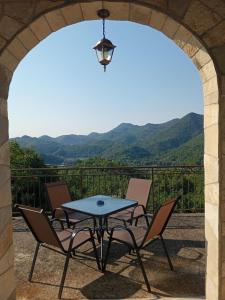a table and chairs on a patio with mountains in the background at Villa Marija in Cetinje