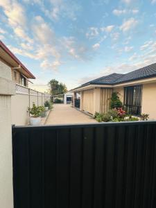 a black fence in front of a house at Cowra Guest House in Cowra