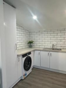a kitchen with a washing machine and a sink at Cowra Guest House in Cowra +2 photos