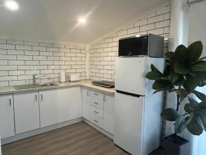 a kitchen with a white refrigerator and a plant at Cowra Guest House in Cowra