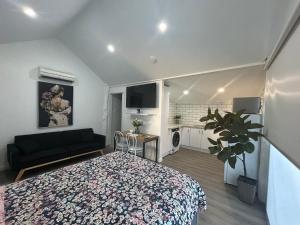 a bedroom with a bed and a living room at Cowra Guest House in Cowra
