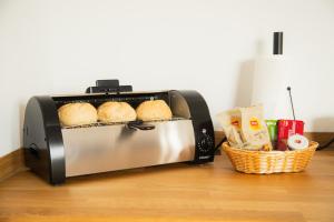a toaster oven with bread and a basket of food at Planet Blue Smartments in Sulzbach an der Murr