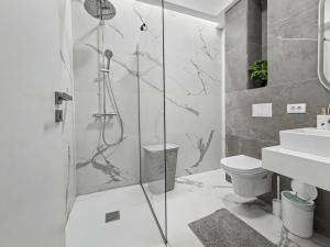 a bathroom with a shower and a toilet and a sink at Tomis Villa Grand Resort in Mamaia Sat/Năvodari +69 photos