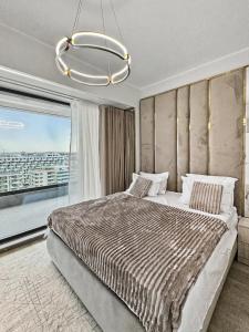 a bedroom with a large bed with a large window at Tomis Villa Grand Resort in Mamaia Sat/Năvodari