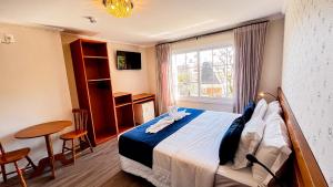 a hotel room with a bed and a window at Lapônia Hotel Gramado in Gramado
