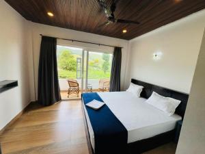 a bedroom with a large bed and a balcony at Pine Trees Home Holidays in Vagamon
