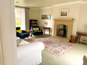 a living room with a white couch and a fireplace at Crossing Gates House in Dundrum