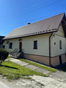 a white building with a metal roof at Domek u Krzyśka in Słopnice +8 photos