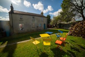 a group of chairs and a table in front of a house at Crossing Gates House in Dundrum
