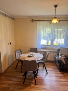 a living room with a table and chairs and a couch at Domek u Krzyśka in Słopnice