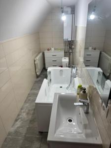 a bathroom with two sinks and a mirror at Domek u Krzyśka in Słopnice