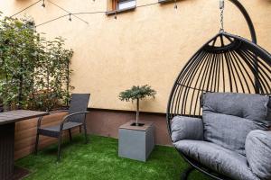 a patio with a swing and a couch and a chair at Penzion ZENIT in Prešov