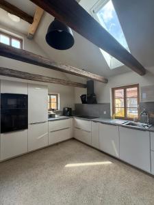 a large kitchen with white cabinets and a skylight at Fachwerk Anno 1789 in Lemgo +5 photos