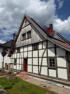 a white and black house with a red door at Fachwerk Anno 1789 in Lemgo